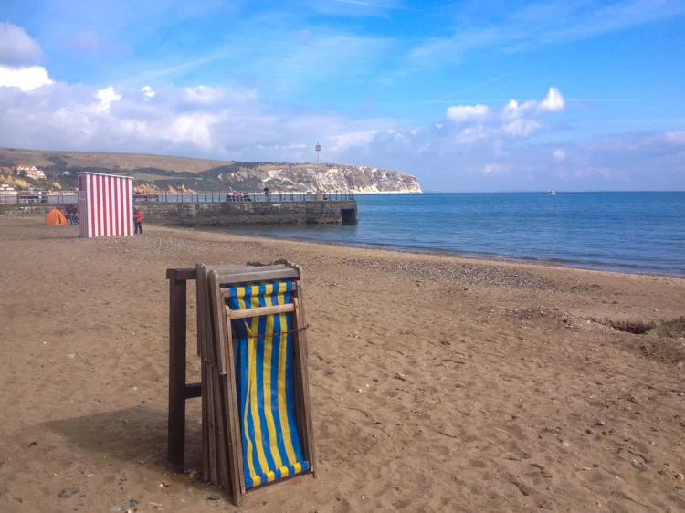 Swanage beach, sandy and with folded deckchairs