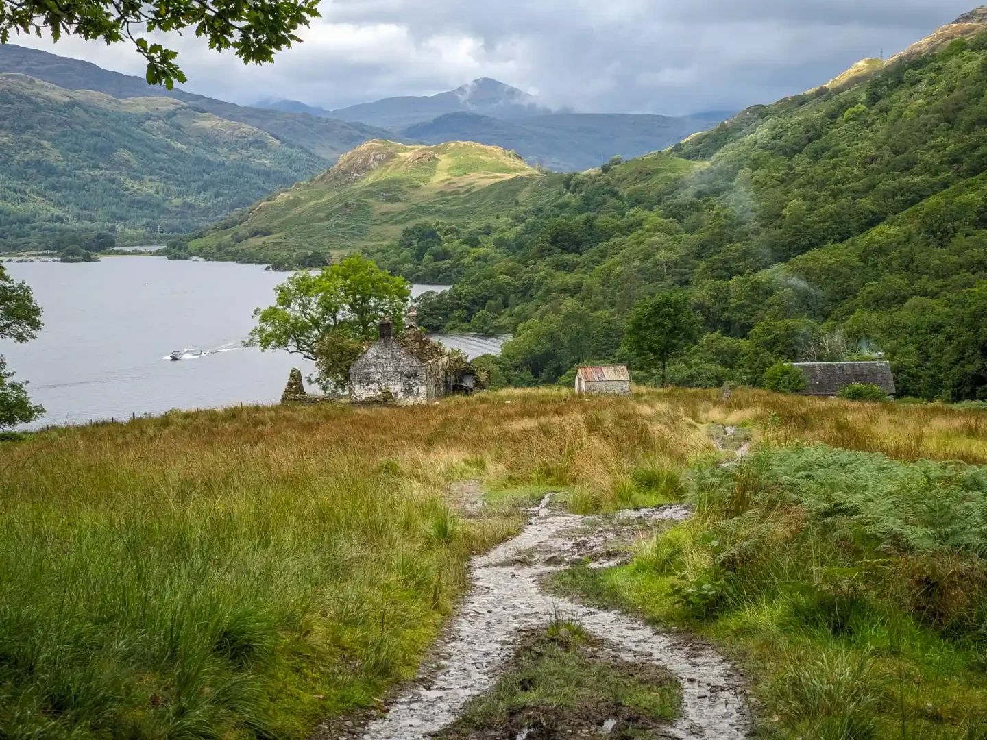 At the top of Loch Lomond, smoke rises from a bothy and a couple of derelict buildings nestle at the bottom of the mountains.